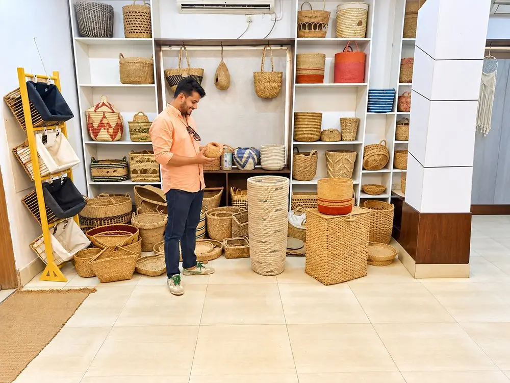 RES Eco-Craft team member inspecting a handwoven basket in the showroom